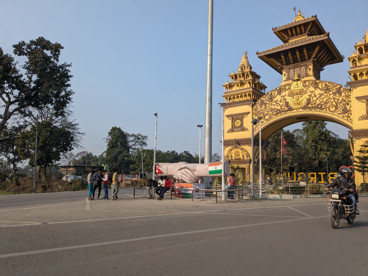 The ornate Nepal–India friendship gateway at Birgunj, with the handshake monument in the foreground.